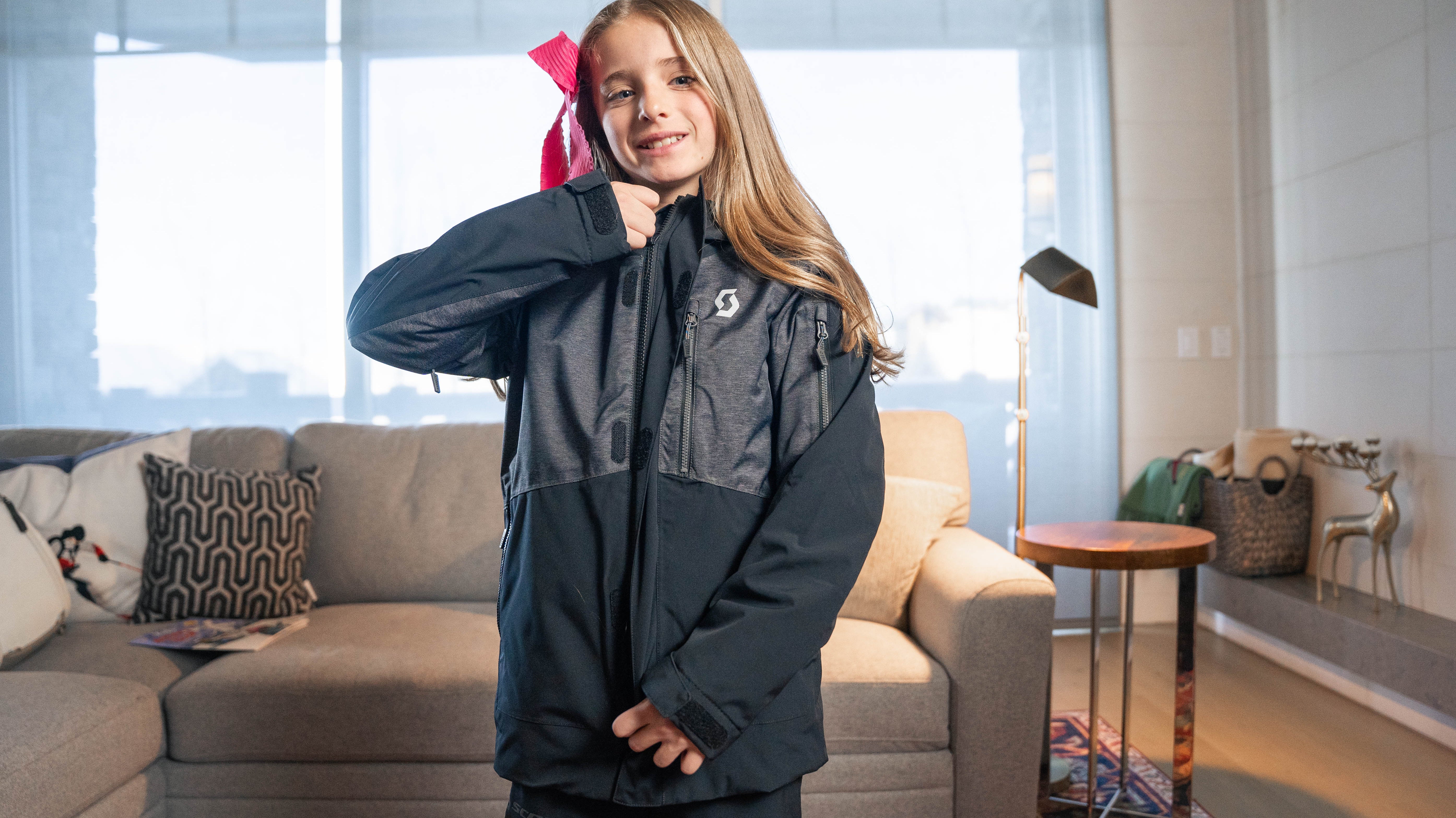 A teenage girl zipping up her jacket after renting ski clothes in Park City