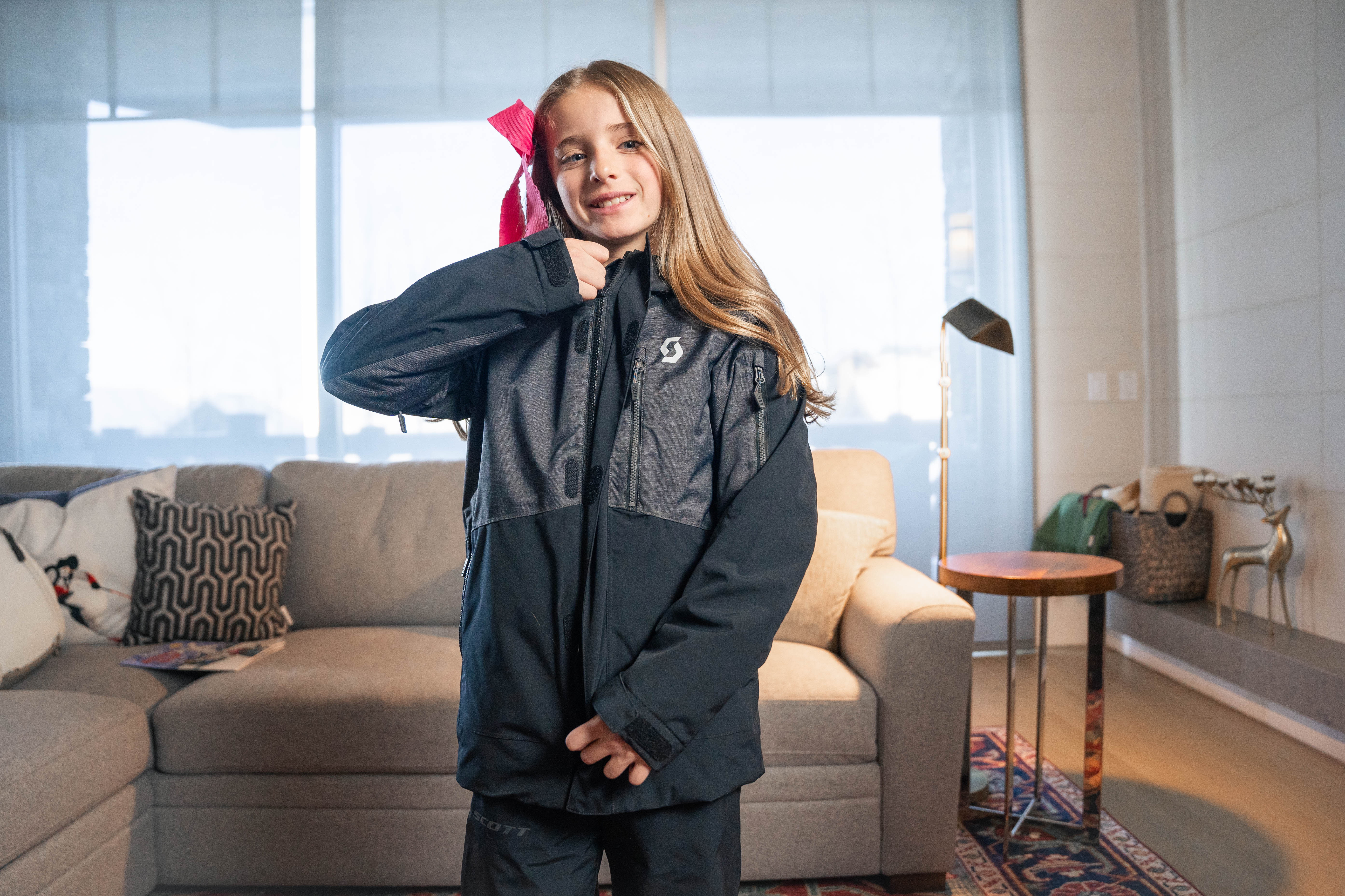 A teenage girl zipping up her jacket after renting ski clothes in Park City