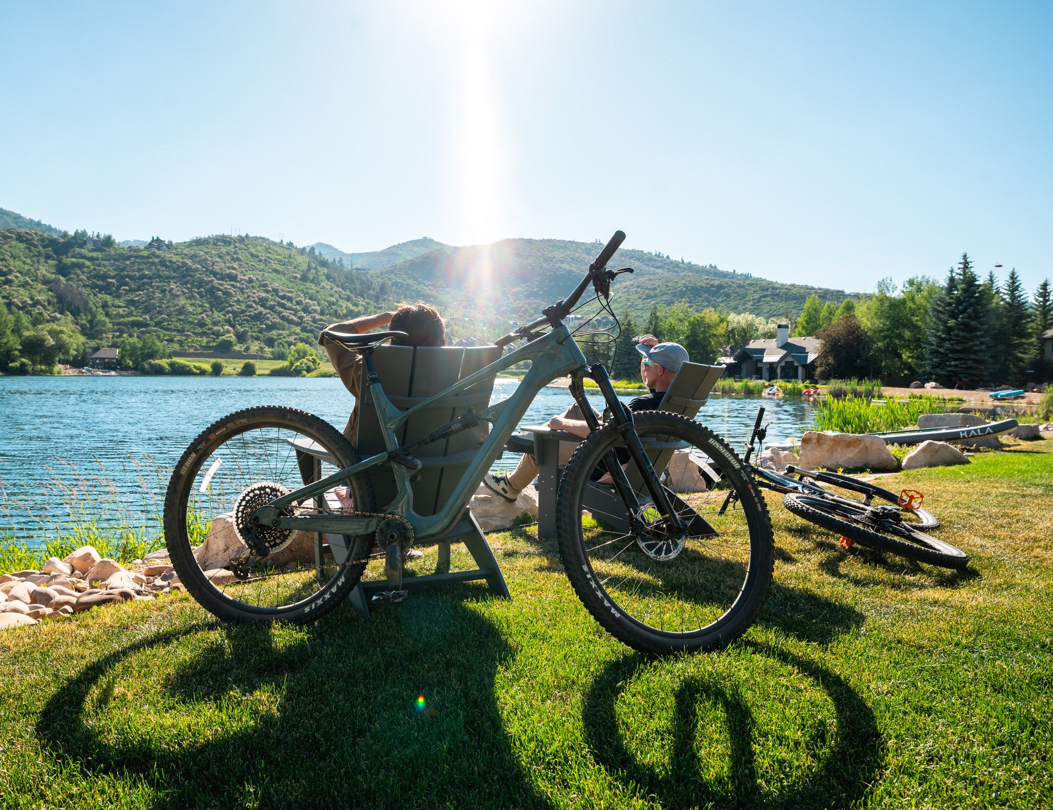 Two people sitting on chairs looking at a lake after using Skis on the Run for a bike rental delivery