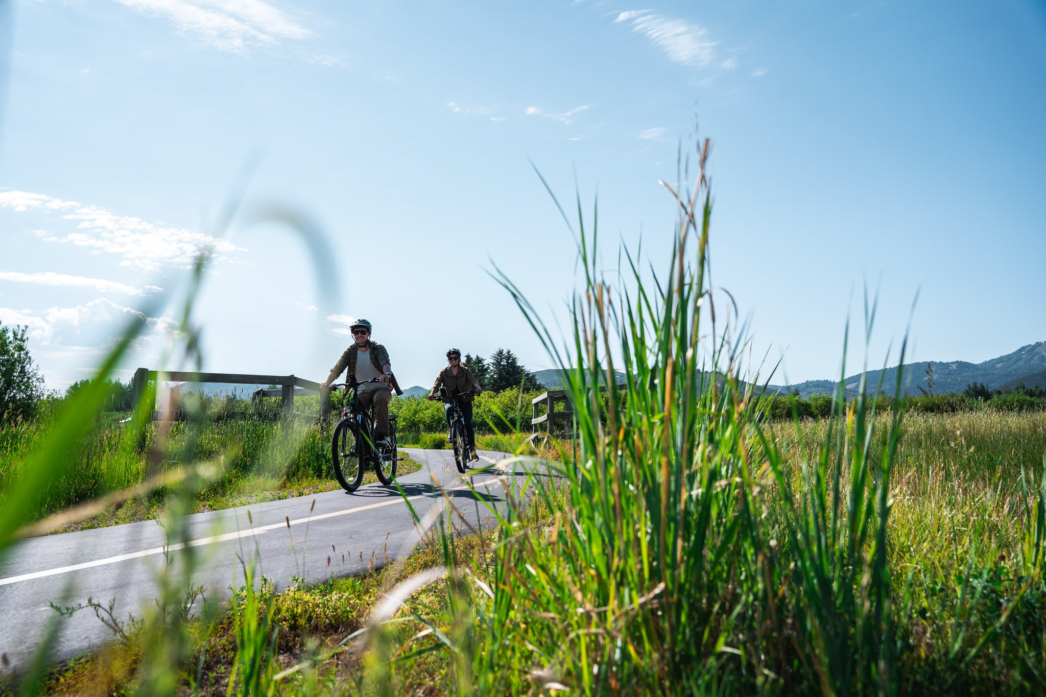 Two people riding on electric city bikes on the Mcpolin Farm Nature Trail. 